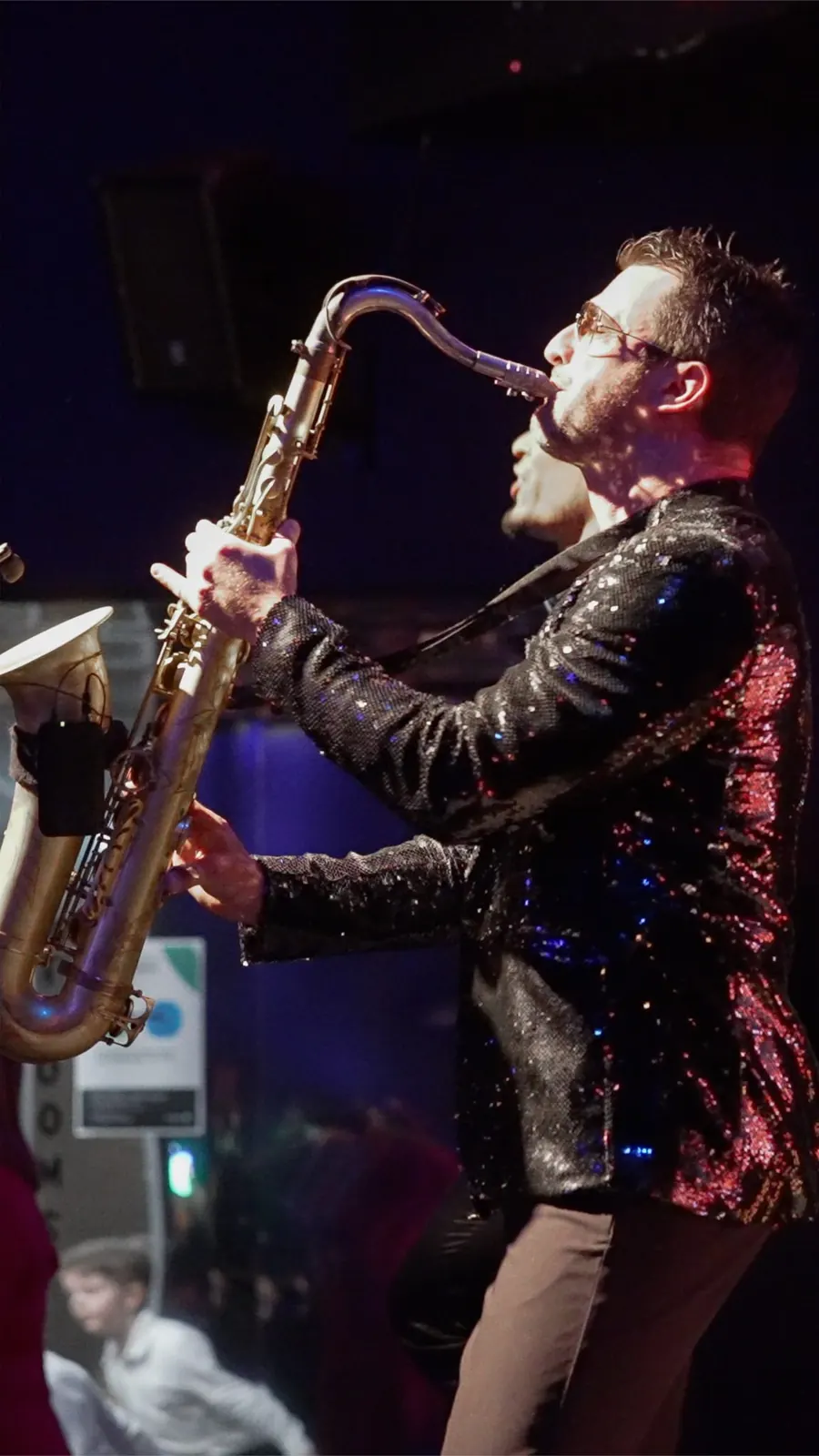 Saxophonist performing in a sequin jacket