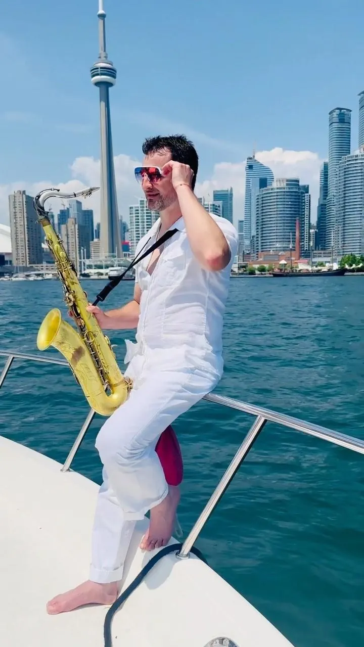 Saxophonist on a boat with the Toronto skyline